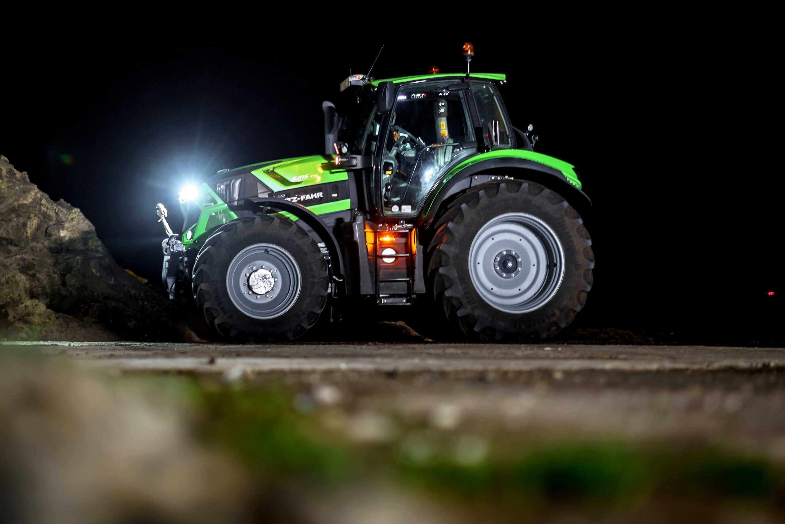 Grøn traktor med lysende forlygter